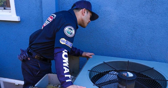 Technician inspecting heat pump unit.