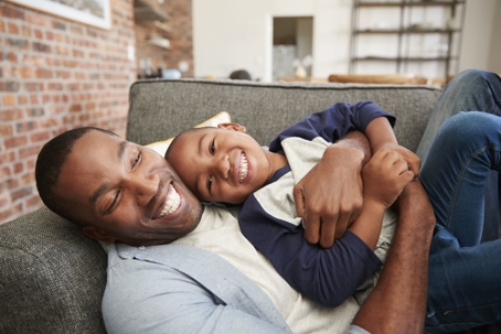 happy father and son hugging on the couch