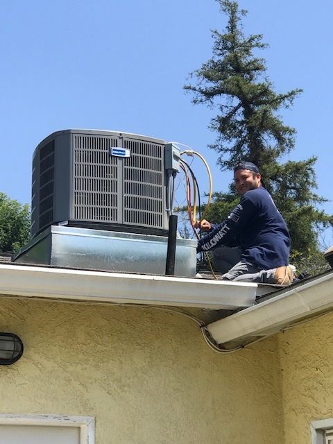 Kilowatt AC Service technician with rooftop compressor