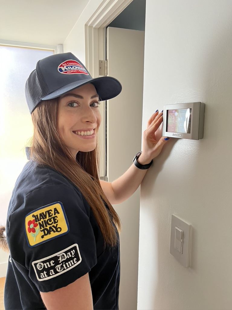 beautiful service technician fixing thermostat